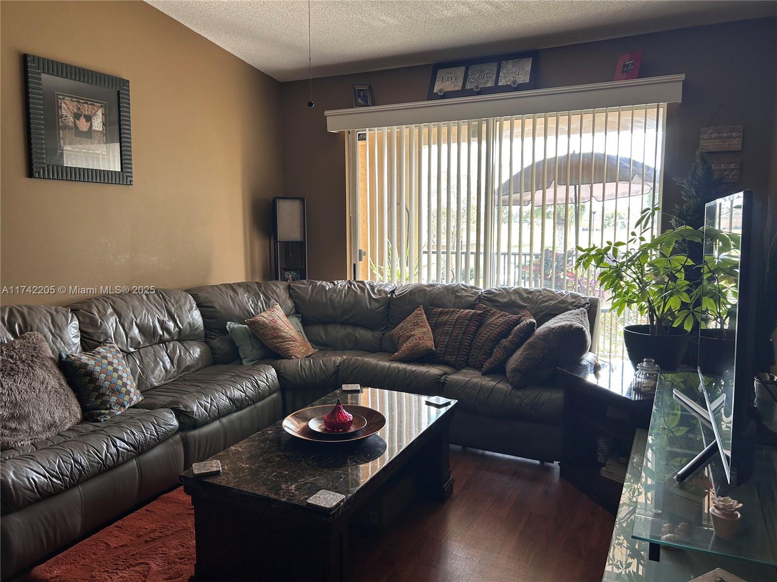 7940 North Nob Hill Road, Unit 201 Tamarac, FL 33321 - Photo 4 of 10 a living room with furniture and a large window