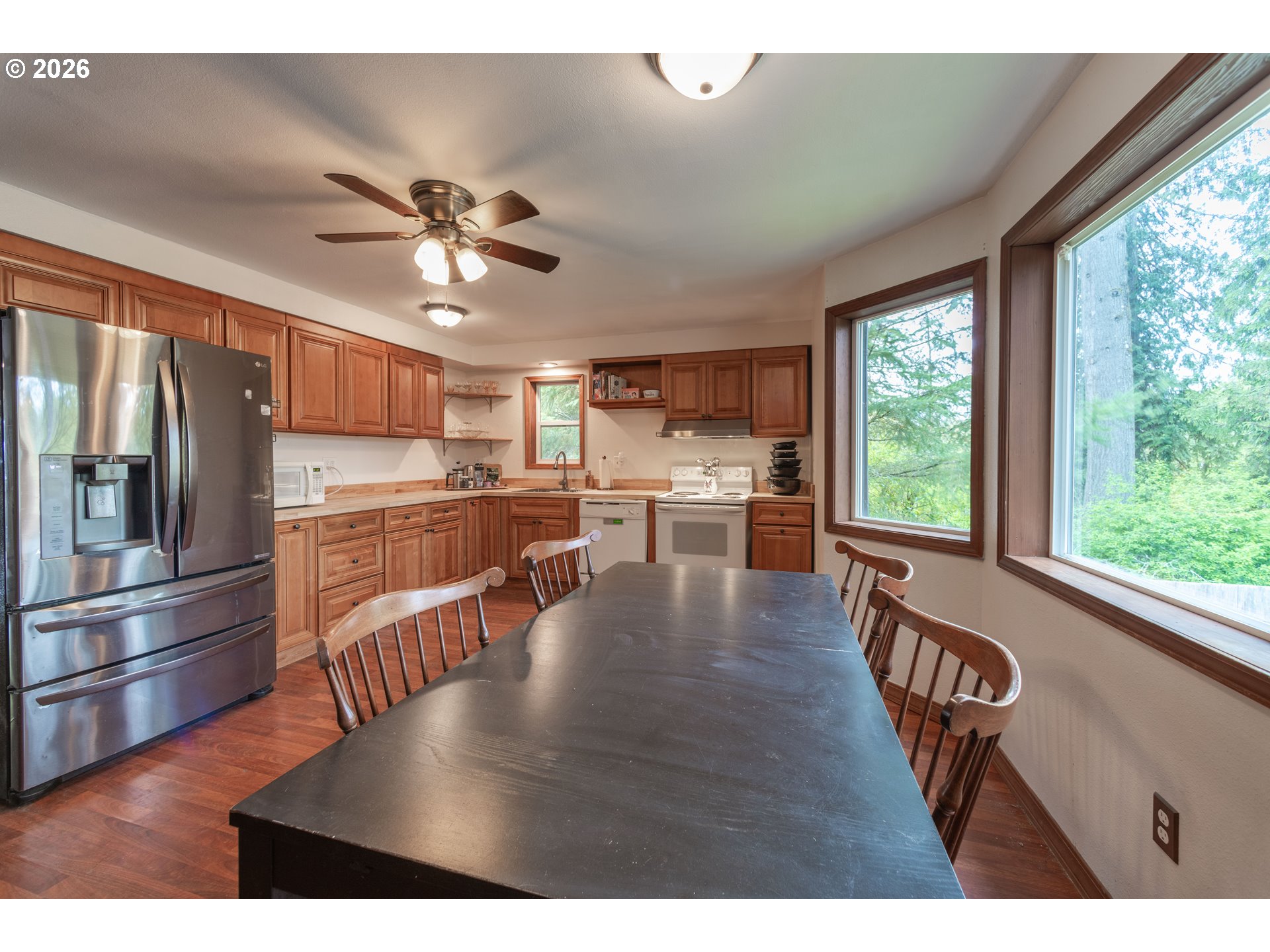 60045 Northwest Railroad Avenue Timber, OR 97144 - Photo 12 of 41 a kitchen with stainless steel appliances granite countertop a refrigerator a stove a sink dishwasher a dining table and chairs with wooden floor