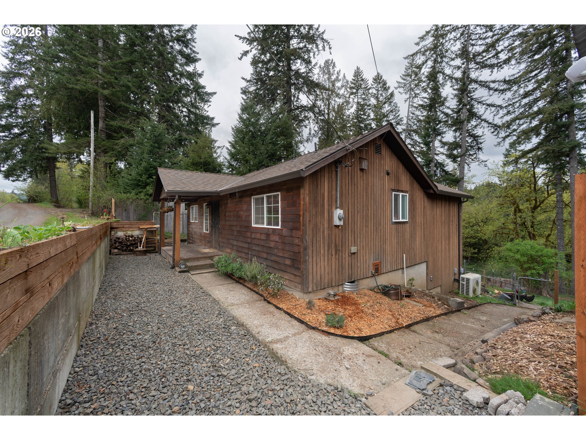 60045 Northwest Railroad Avenue Timber, OR 97144 - Photo 3 of 41 a backyard of a house with large trees and wooden fence