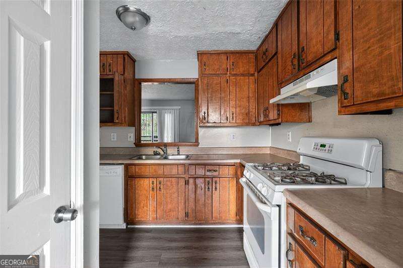 5957 Friar Court, Unit A Atlanta, GA 30349 - Photo 3 of 16 a kitchen with stainless steel appliances granite countertop a stove a sink and a refrigerator