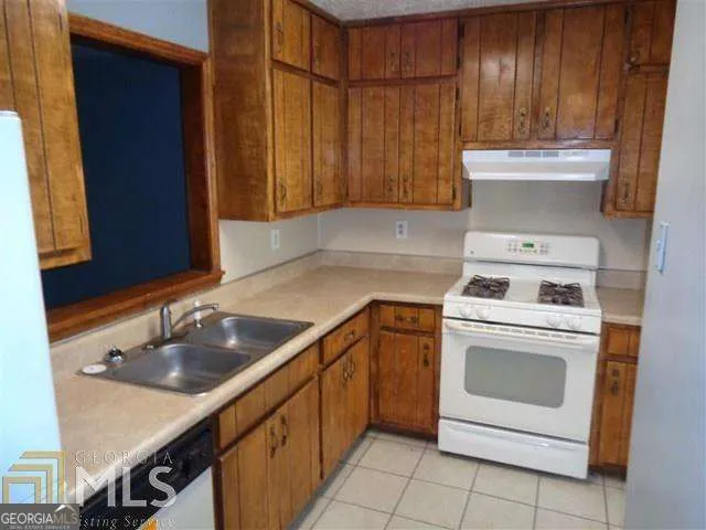 a kitchen with a sink stove and cabinets