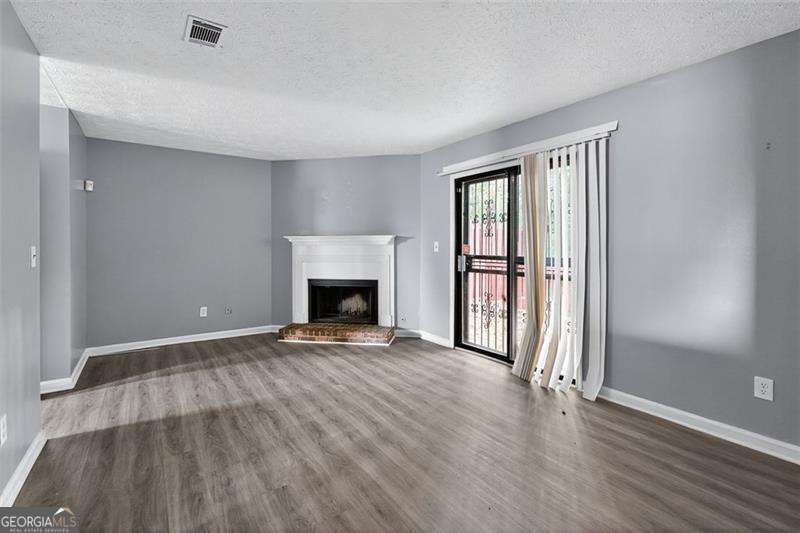 5957 Friar Court, Unit A Atlanta, GA 30349 - Photo 6 of 16 wooden floor fireplace and natural light in room