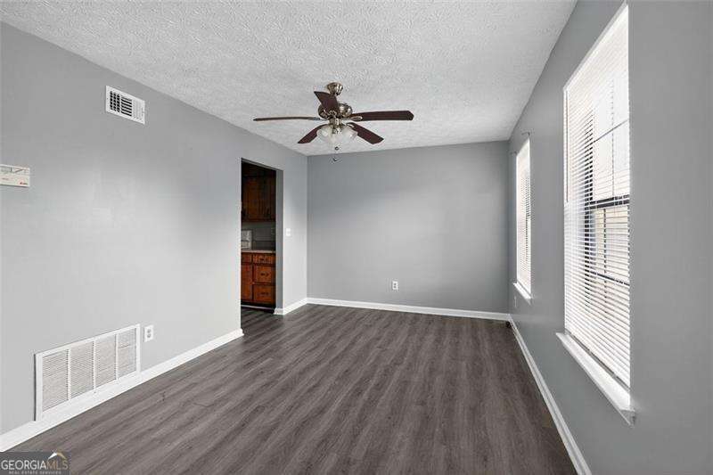 5957 Friar Court, Unit A Atlanta, GA 30349 - Photo 9 of 16 wooden floor in an empty room with a window