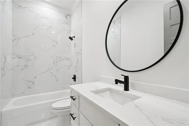 a bathroom with a sink a toilet and a mirror