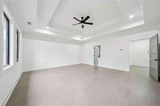 an empty room with a ceiling fan and window