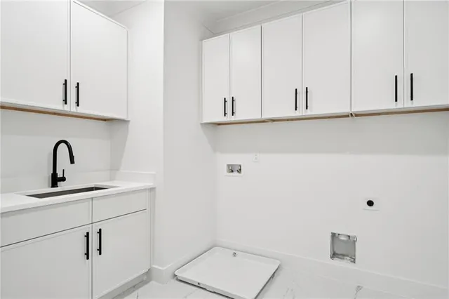a close view of a sink and cabinets in a white cabinet