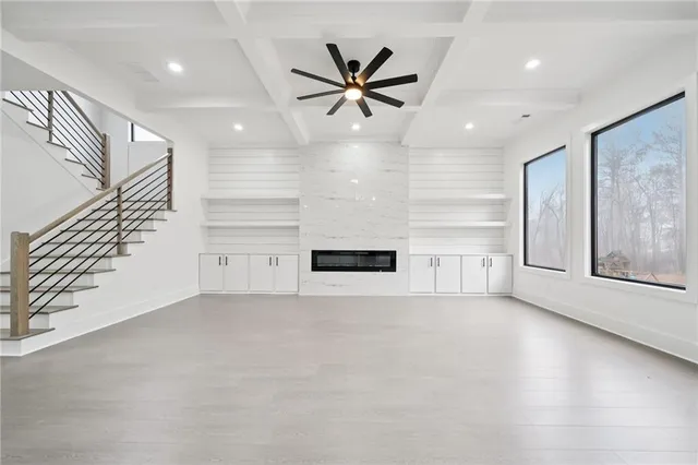 an empty room with windows and ceiling fan