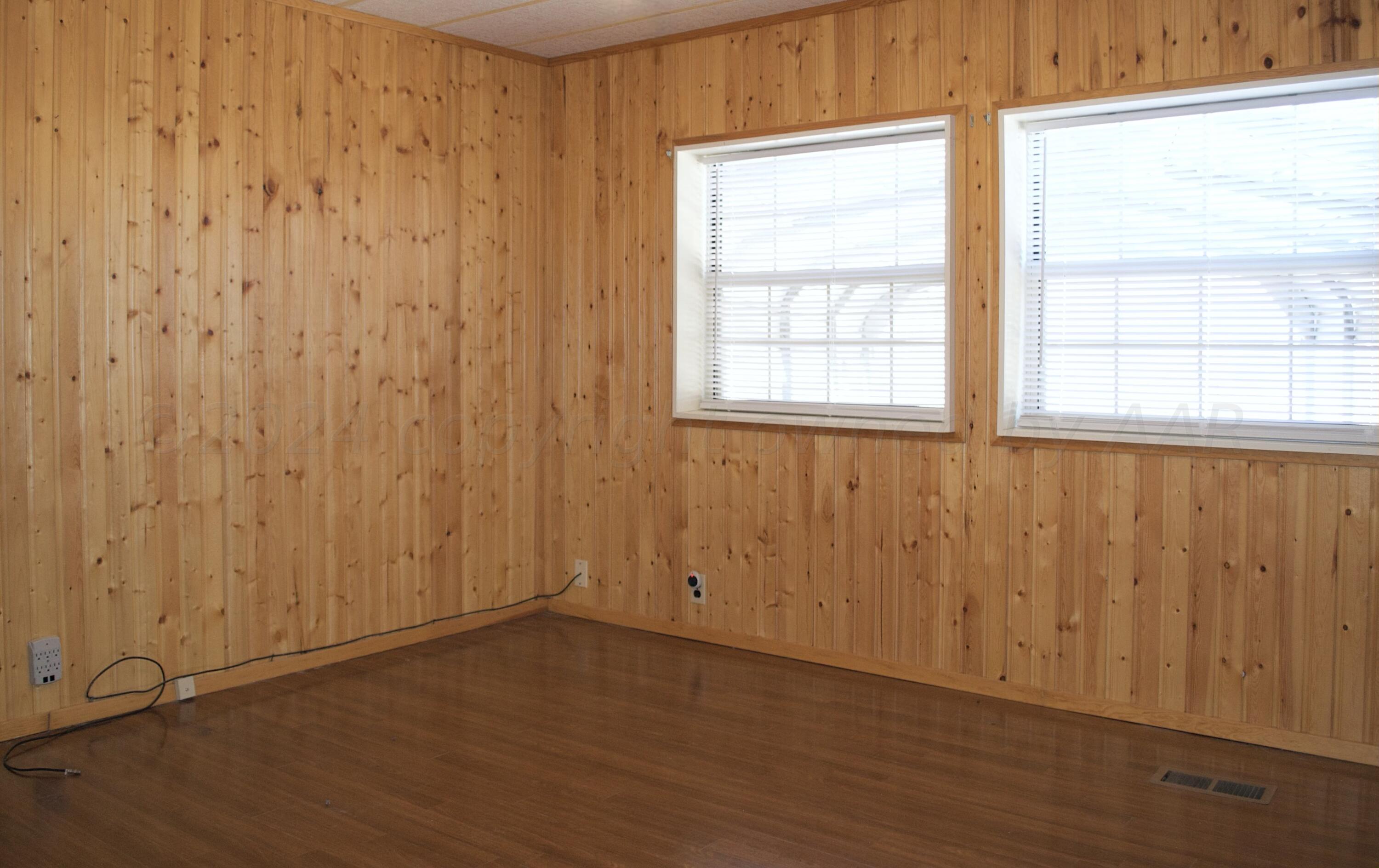 531 West Studebaker Avenue Amarillo, TX 79108 - Photo 17 of 25 an empty room with wooden floor and windows with curtains