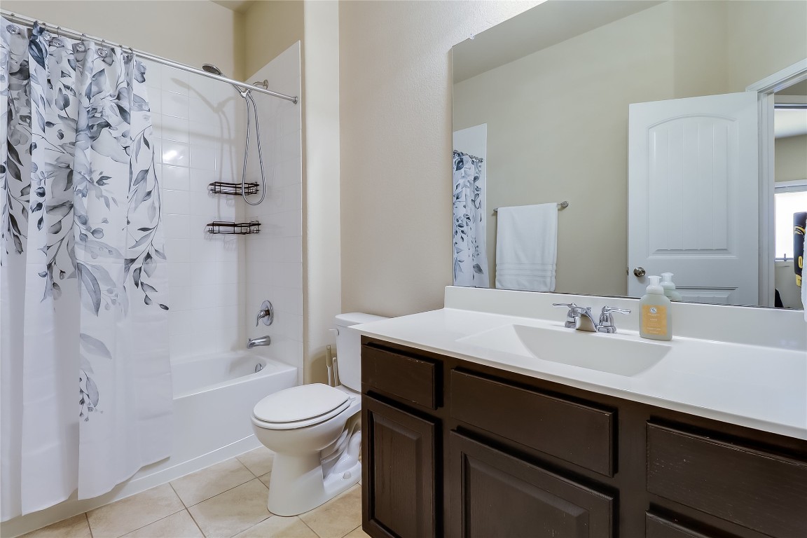 1425 Hamiltons Way Leander, TX 78641 - Photo 12 of 38 a bathroom with a sink a toilet and a large mirror