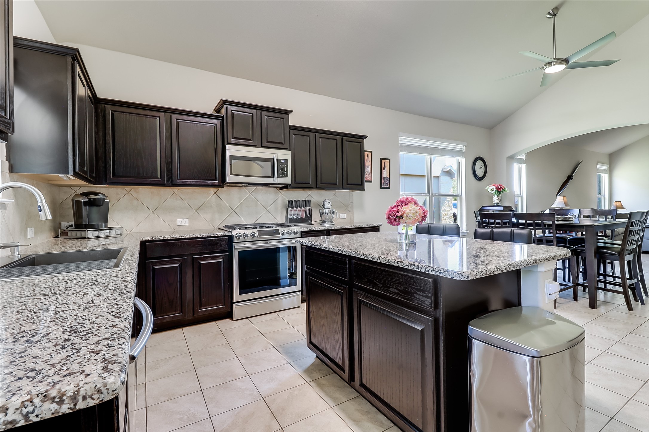 1425 Hamiltons Way Leander, TX 78641 - Photo 17 of 38 a kitchen with stainless steel appliances kitchen island granite countertop a stove a sink and a microwave