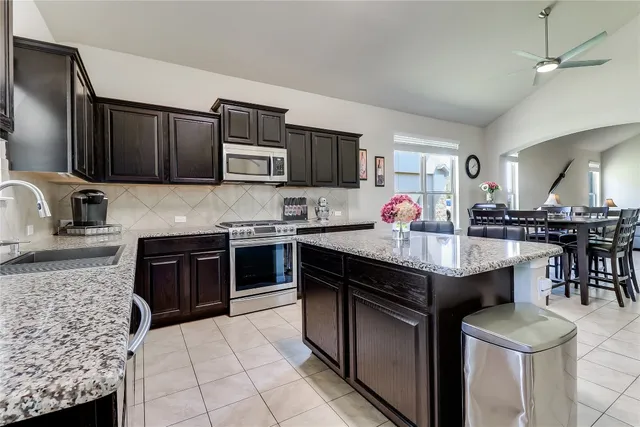 a kitchen with granite countertop stainless steel appliances and wooden cabinets