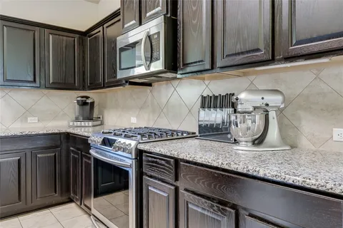 a kitchen with stainless steel appliances granite countertop a sink stove and microwave