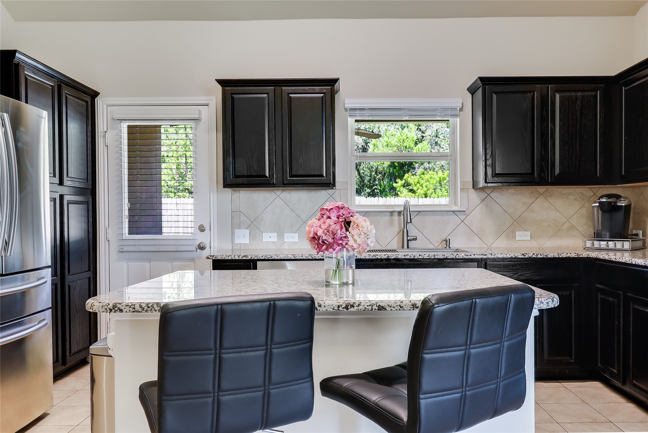 1425 Hamiltons Way Leander, TX 78641 - Photo 23 of 38 a kitchen with granite countertop a stove refrigerator and microwave