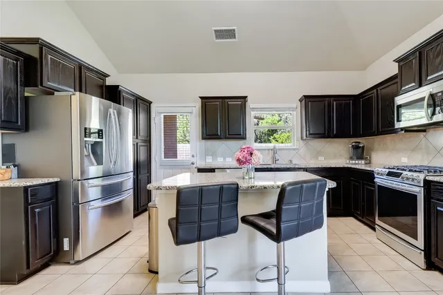 a kitchen with stainless steel appliances a stove a sink refrigerator and cabinets