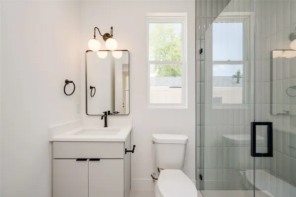 a bathroom with a toilet sink and mirror