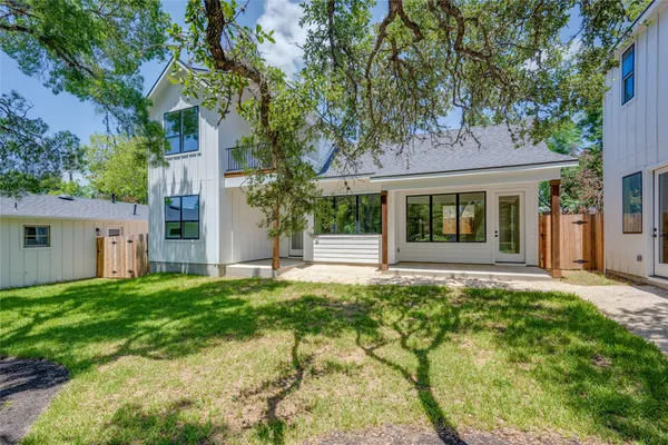 a front view of a house with a yard and trees