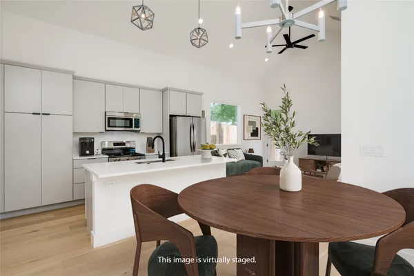 a kitchen with a table chairs and white cabinets