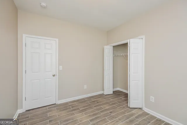 a view of an empty room with wooden floor