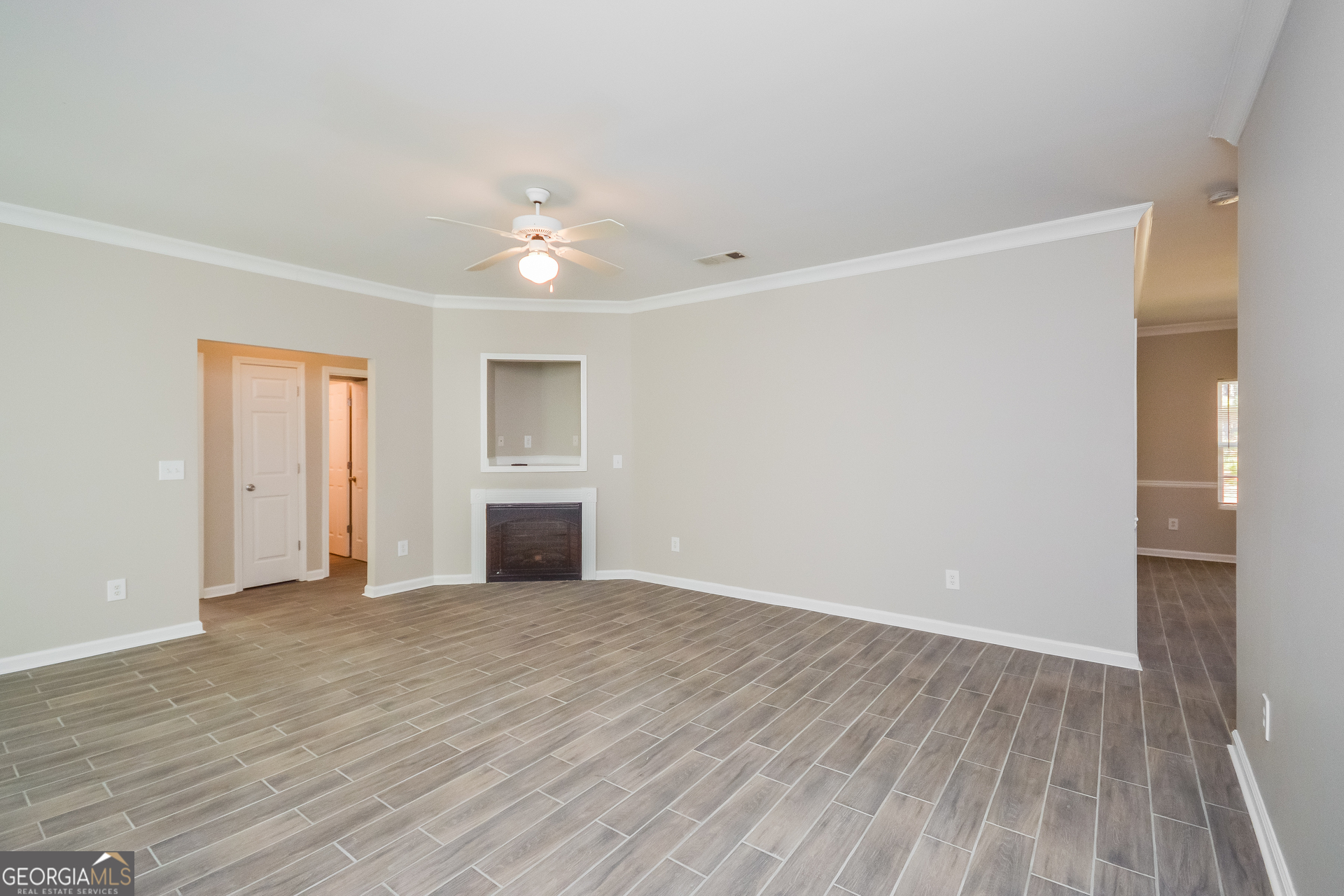 70 Joshua Creek Road Covington, GA 30016 - Photo 3 of 15 a view of empty room with wooden floor and ceiling fan