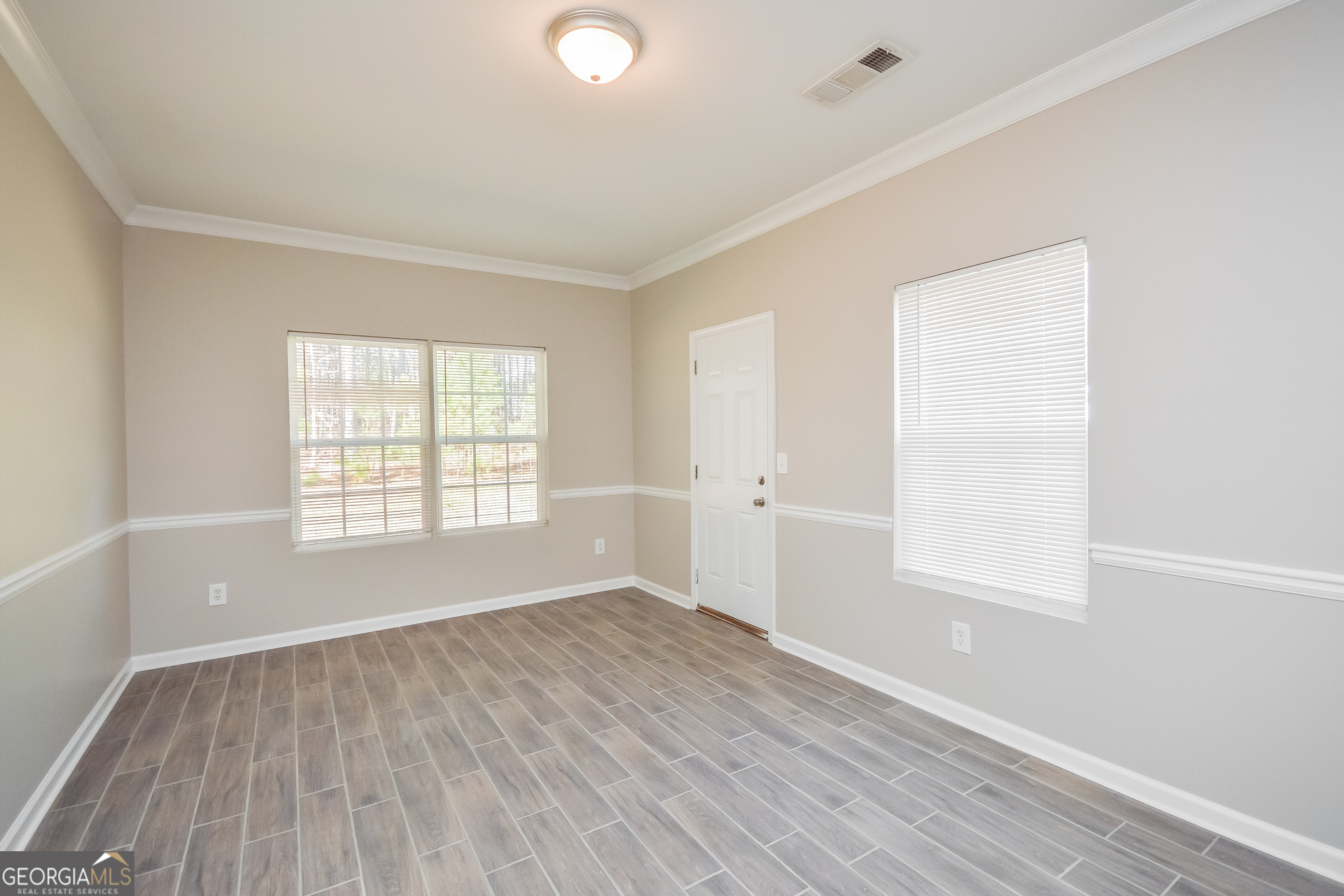 70 Joshua Creek Road Covington, GA 30016 - Photo 4 of 15 an empty room with wooden floor and windows