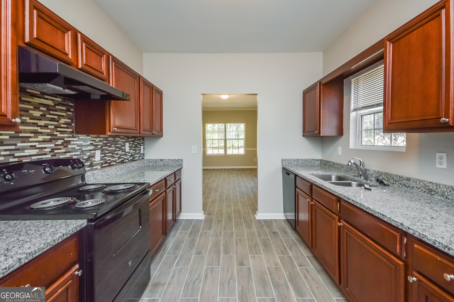 70 Joshua Creek Road Covington, GA 30016 - Photo 7 of 15 a kitchen with stainless steel appliances granite countertop wooden cabinets stove top oven and sink