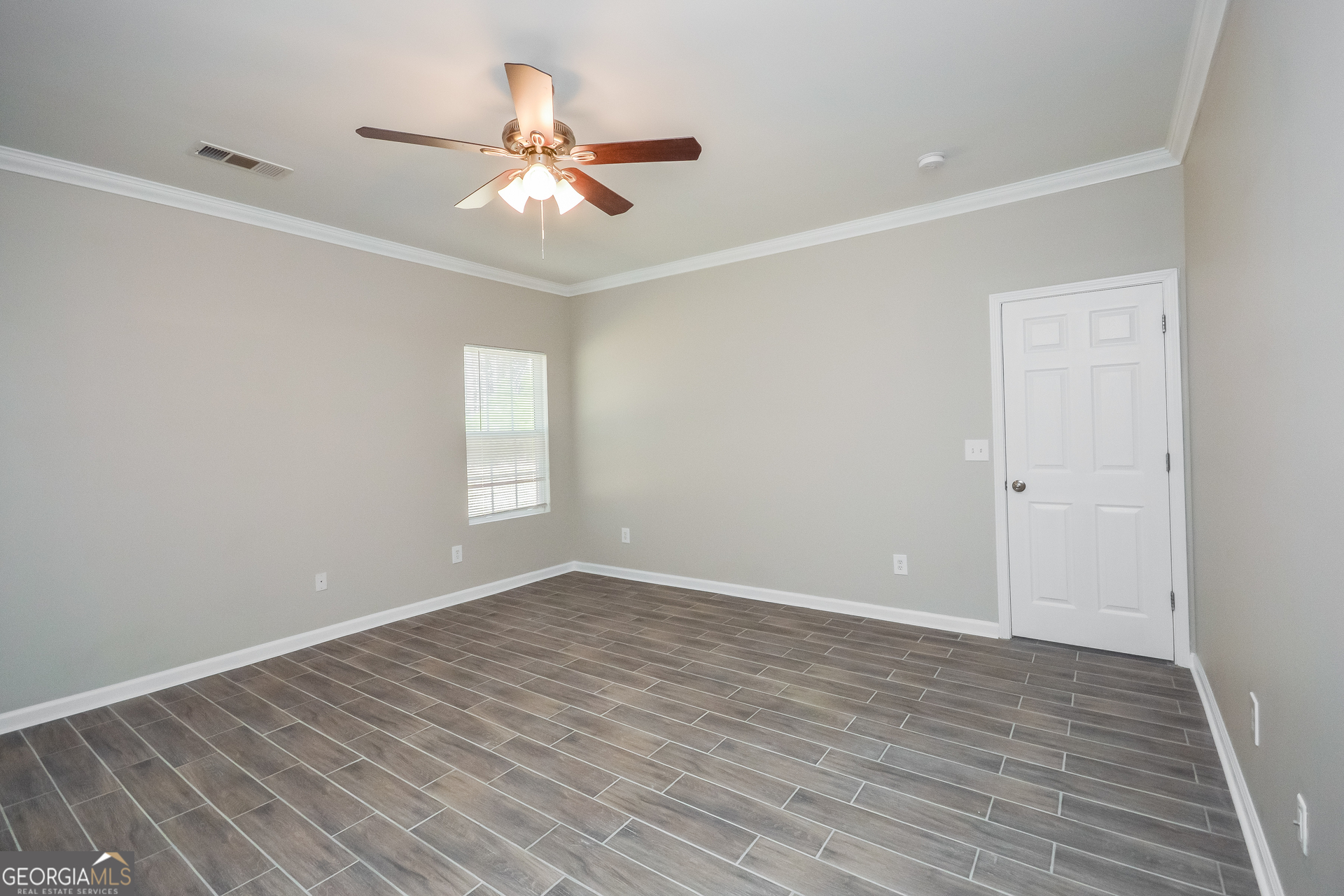 70 Joshua Creek Road Covington, GA 30016 - Photo 9 of 15 a view of an empty room with wooden floor and a ceiling fan