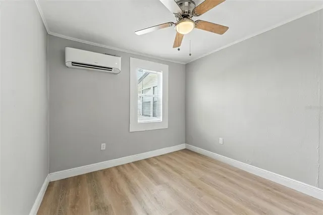 an empty room with a window and a fan