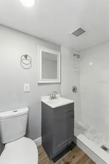 a bathroom with a sink a toilet and shower