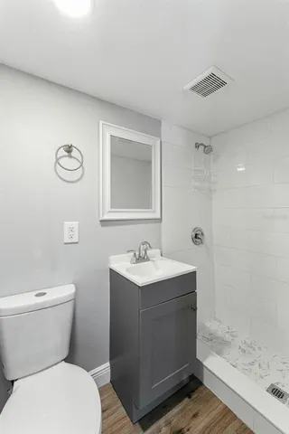 a bathroom with a sink a toilet and shower