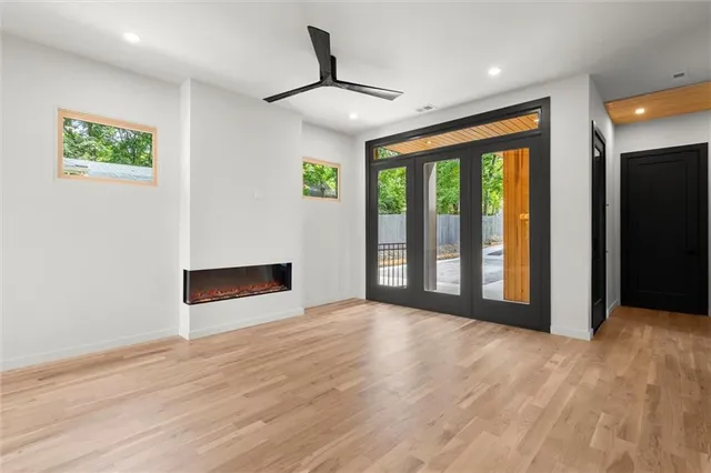 a view of an empty room with a window and kitchen view
