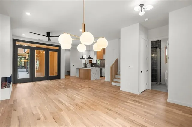 a kitchen with stainless steel appliances granite countertop a sink a stove and a wooden floors