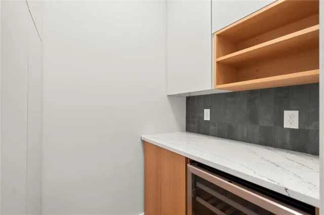 a view of an empty room with window and bathroom