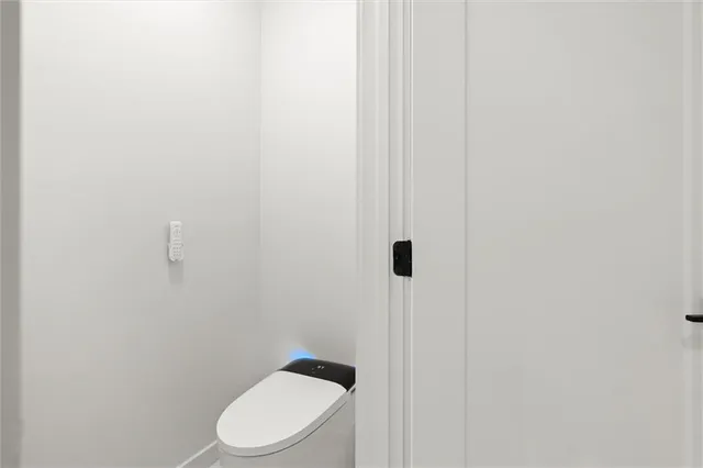 a bathroom with a granite countertop toilet and a sink