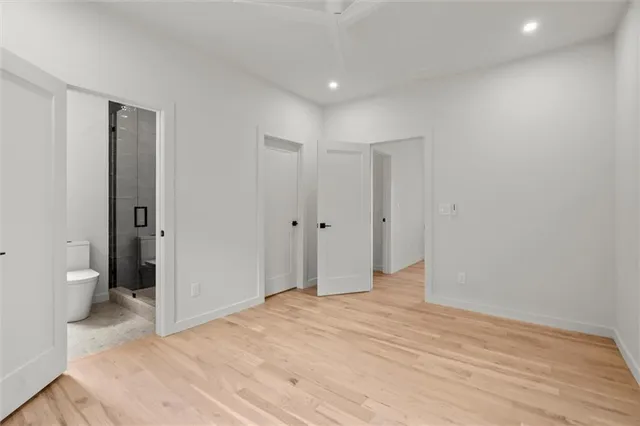 a view of a room with a ceiling fan and hardwood floor