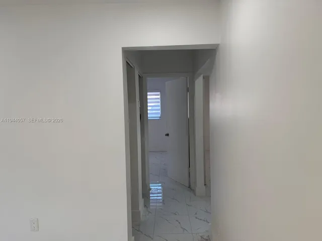 a view of a hallway with wooden cabinets