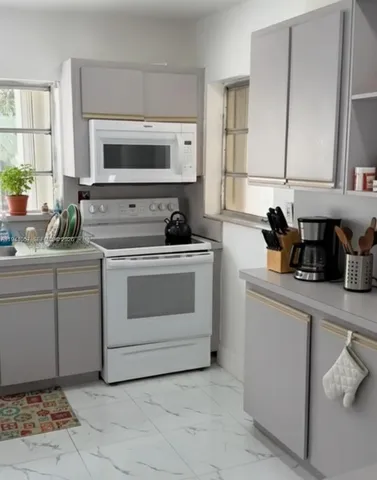 a kitchen with a stove sink and cabinets