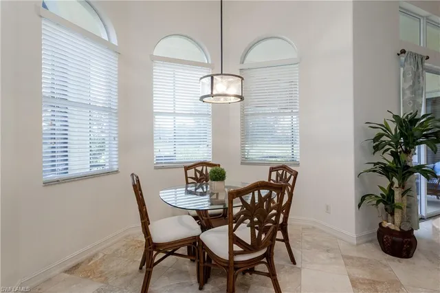a dining room with furniture and potted plants