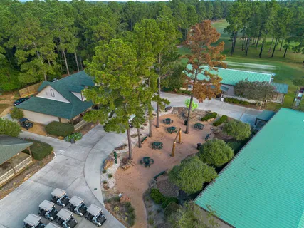 an aerial view of a tennis ground and a cars park side of the road