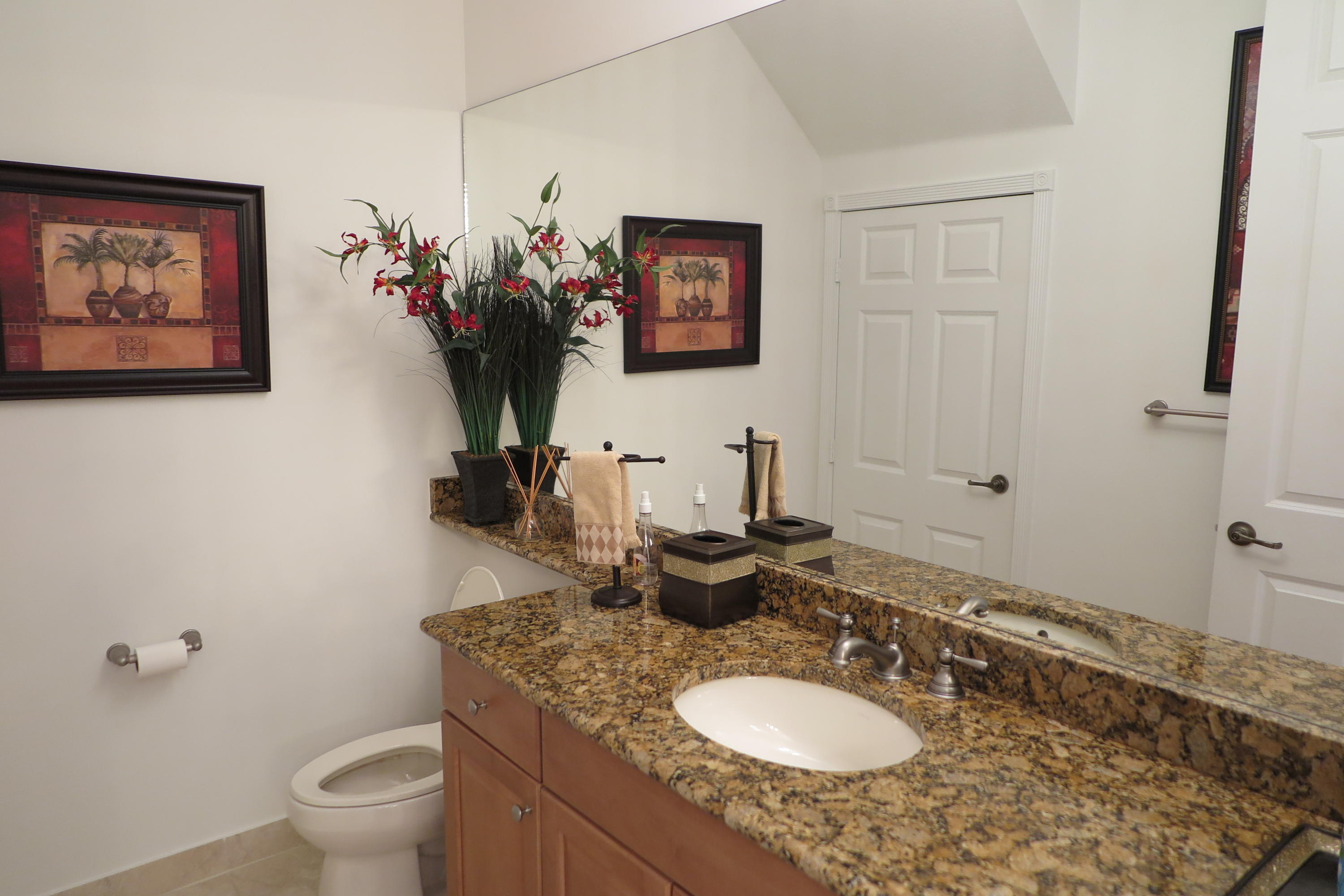 819 Northwest 82nd Place Boca Raton, FL 33487 - Photo 18 of 25 a bathroom with a granite countertop sink a toilet and a mirror