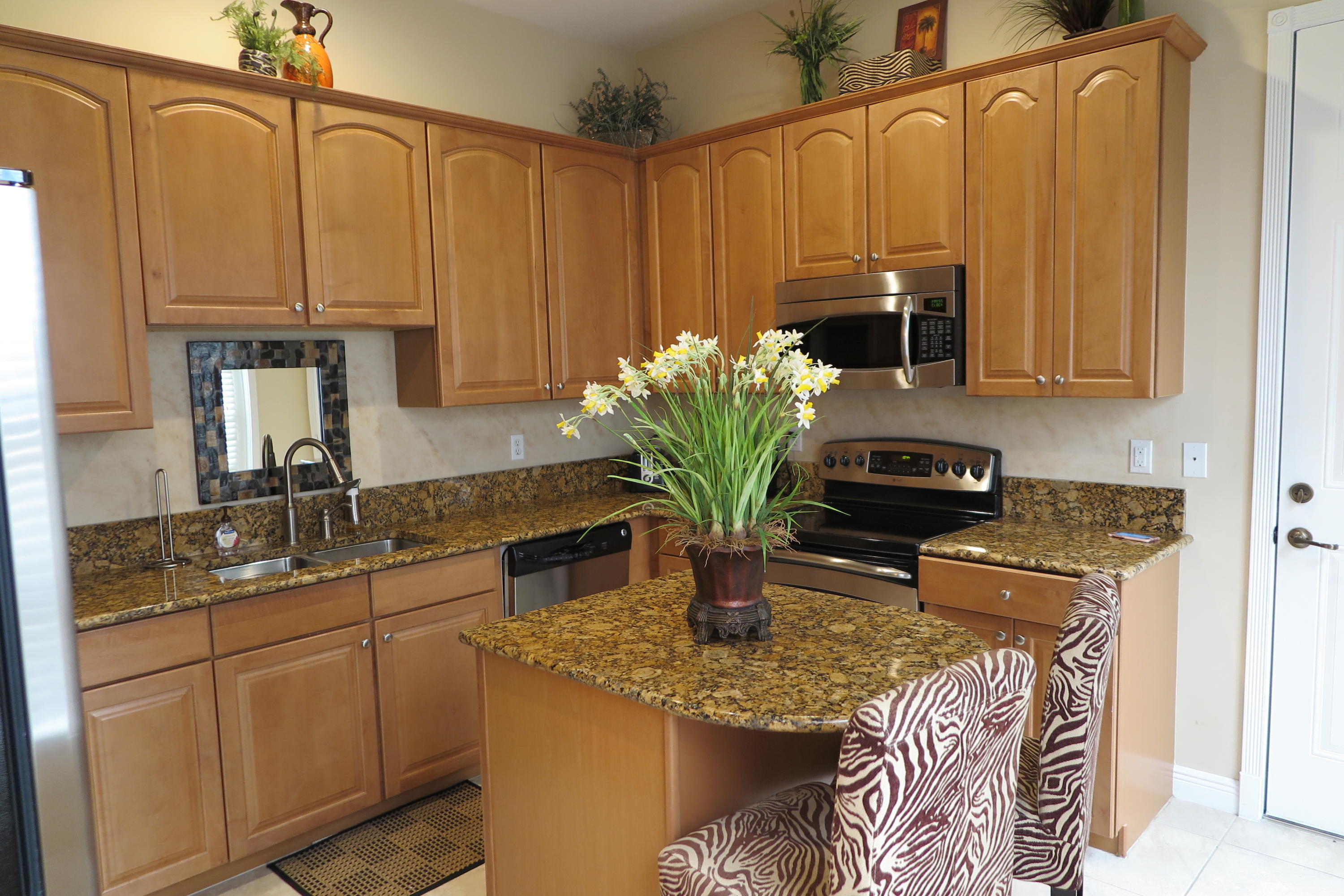 819 Northwest 82nd Place Boca Raton, FL 33487 - Photo 9 of 25 a kitchen with stainless steel appliances granite countertop a sink a counter space and cabinets