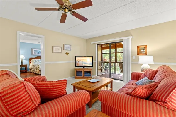 a living room with furniture a large window and a chandelier