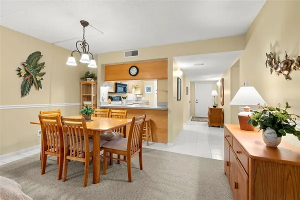 a dining room filled chandelier and wooden floor