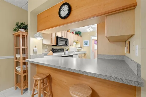 a view of a kitchen with kitchen island a large counter space and stainless steel appliances