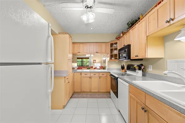 a kitchen with a sink a refrigerator and cabinets