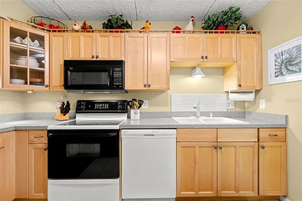 a kitchen with granite countertop a sink stainless steel appliances and cabinets