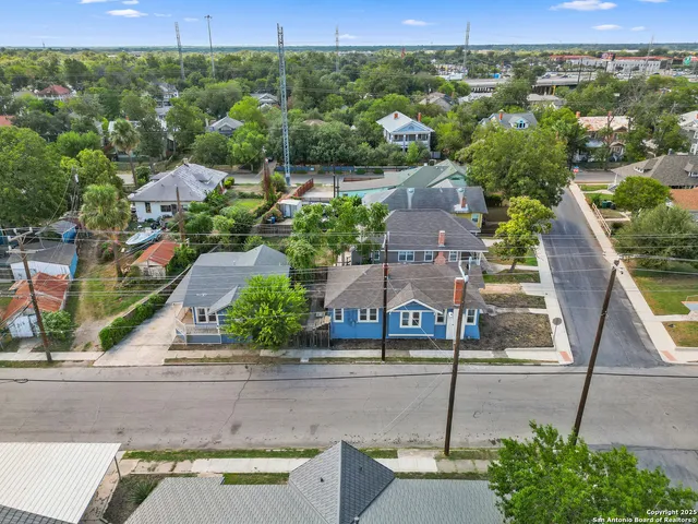 an aerial view of residential houses with outdoor space and parking