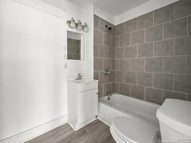 a bathroom with a bathtub a toilet a sink and a mirror