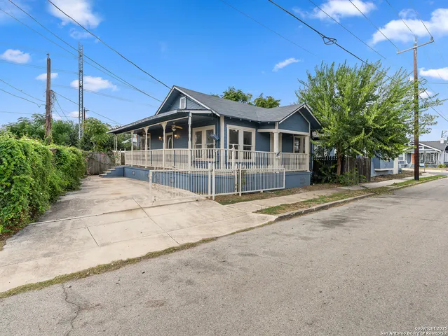 a view of a house with a yard and potted plants