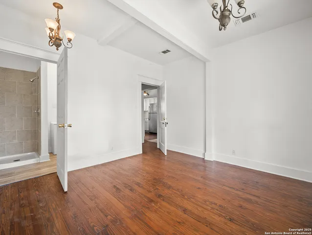 a view of an empty room with wooden floor