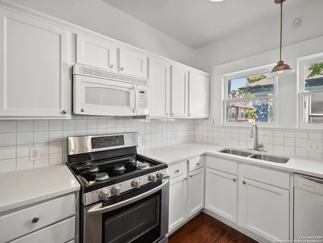 a kitchen with cabinets appliances a sink and a counter top